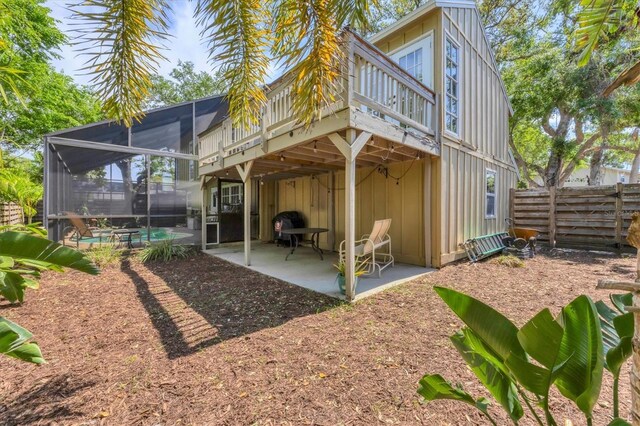 rear view of property with fence, a lanai, a patio, a fenced in pool, and a deck