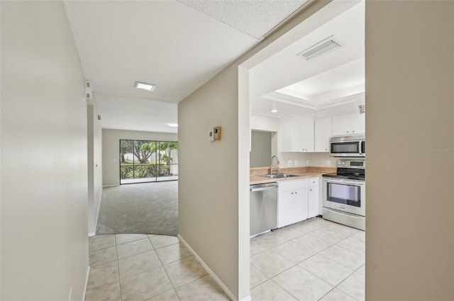 kitchen featuring light countertops, white cabinetry, stainless steel appliances, light tile patterned floors, and visible vents