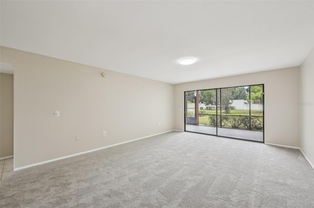 carpeted spare room featuring baseboards