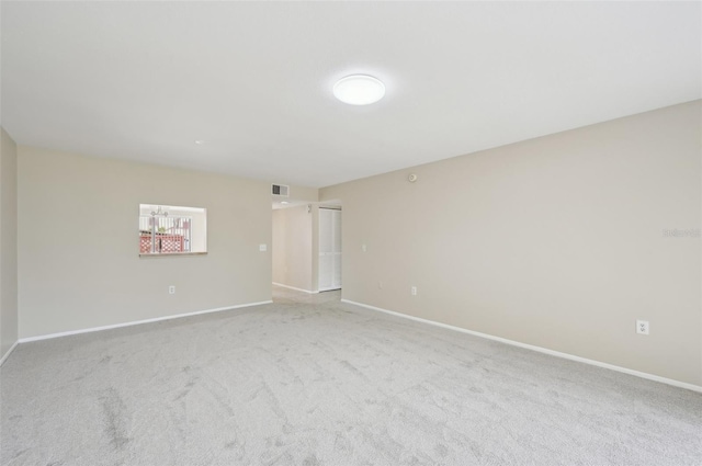 empty room featuring baseboards, carpet flooring, visible vents, and a notable chandelier