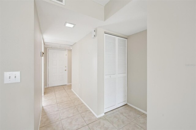 hallway featuring baseboards and light tile patterned floors