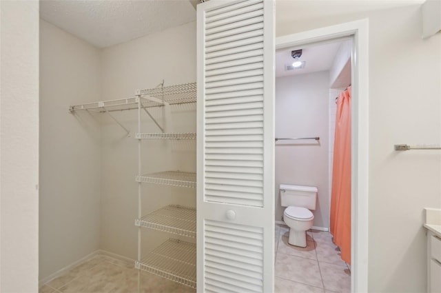 walk in closet featuring light tile patterned flooring
