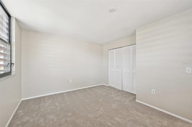 unfurnished bedroom with baseboards, a closet, and carpet flooring