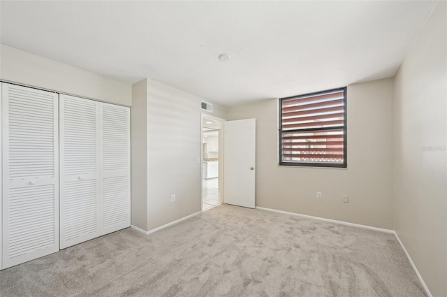 unfurnished bedroom with baseboards, visible vents, a closet, and carpet floors