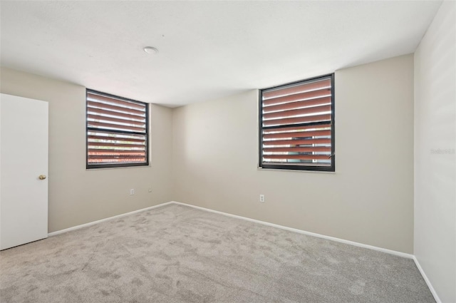 carpeted spare room featuring baseboards