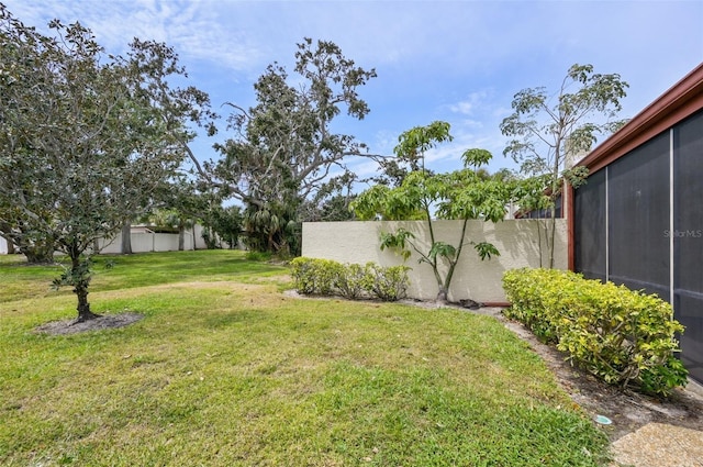 view of yard featuring a sunroom and fence