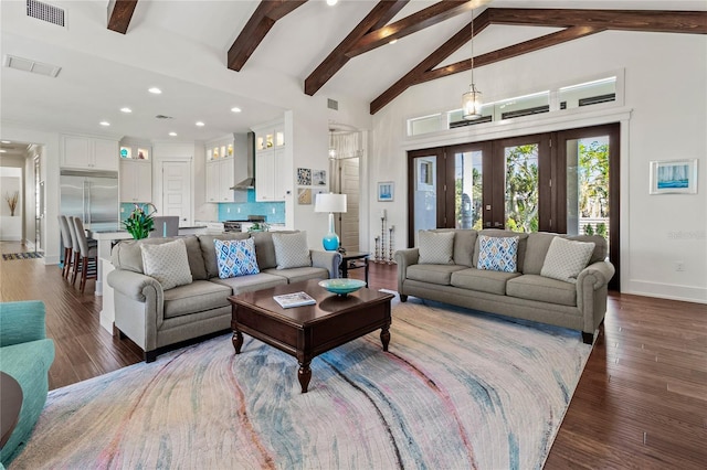 living room with wood finished floors, high vaulted ceiling, and visible vents