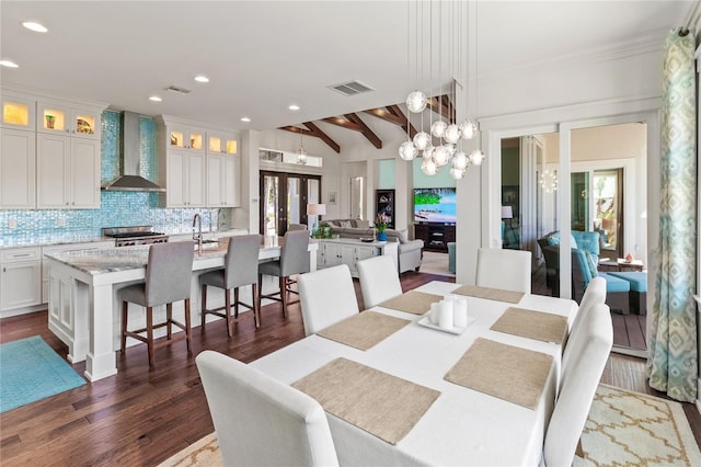 dining space with dark wood-style floors, visible vents, and a wealth of natural light