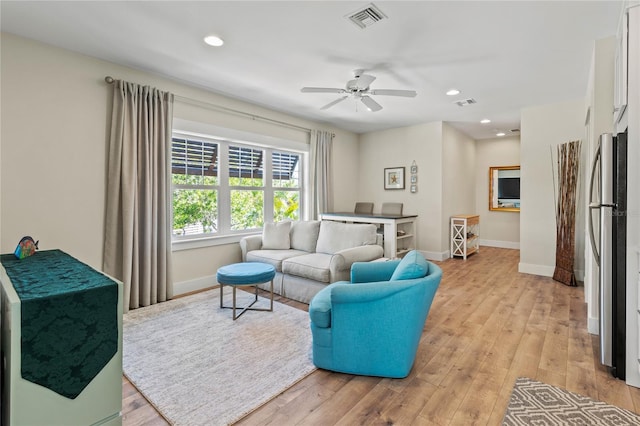 living room with ceiling fan, baseboards, light wood finished floors, and visible vents