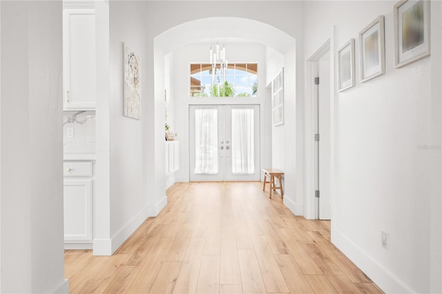 1189 Fraser Pine Blvd, Sarasota, FL 34240 - foyer featuring baseboards, arched walkways, french doors, and light wood finished floors