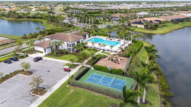 drone / aerial view of a pool area and a large body of water