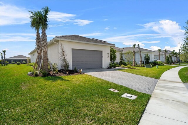 view of front facade with decorative driveway, an attached garage, stucco siding, and a front lawn