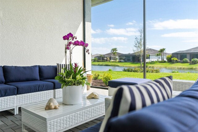 sunroom / solarium featuring a water view and a residential view