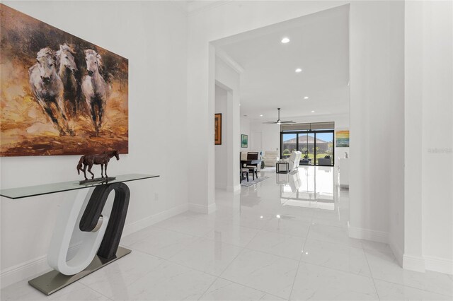 hallway with baseboards, recessed lighting, light marble finish flooring, and crown molding