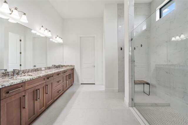 full bathroom featuring a marble finish shower, double vanity, and baseboards