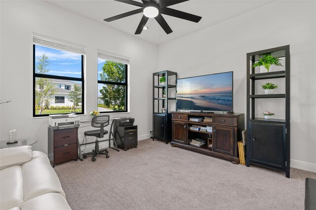 carpeted home office featuring a ceiling fan and baseboards