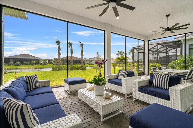 sunroom with ceiling fan, an outdoor hangout area, and a water view
