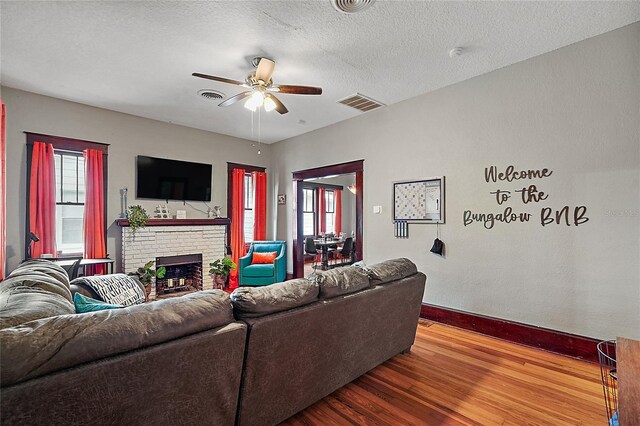 501 Washington Ave, Eustis, FL 32726 - living area featuring a brick fireplace, visible vents, a ceiling fan, and wood finished floors