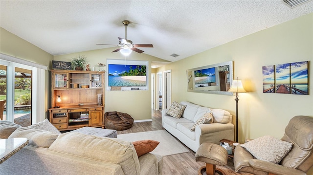 living area with a ceiling fan, a textured ceiling, visible vents, vaulted ceiling, and wood finished floors
