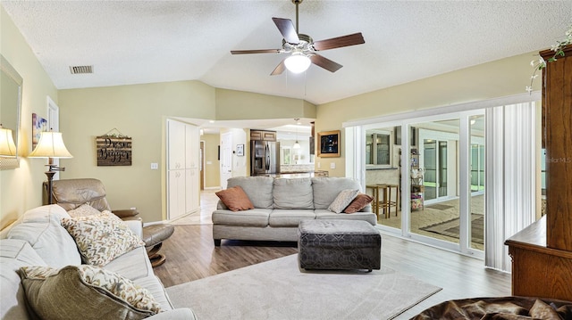 living area featuring a textured ceiling, ceiling fan, wood finished floors, and visible vents