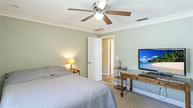 carpeted bedroom with baseboards, ornamental molding, ceiling fan, and visible vents