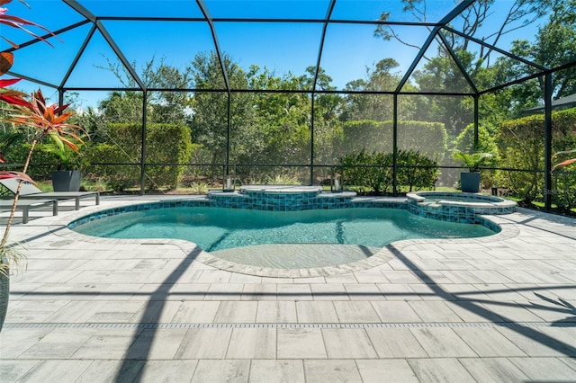 view of swimming pool featuring a pool with connected hot tub, a patio, and a lanai