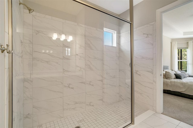 ensuite bathroom with marble finish floors and a shower stall