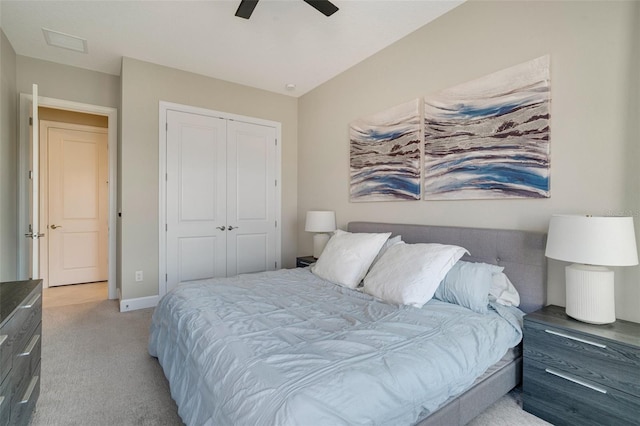 bedroom with a closet, light colored carpet, a ceiling fan, and baseboards