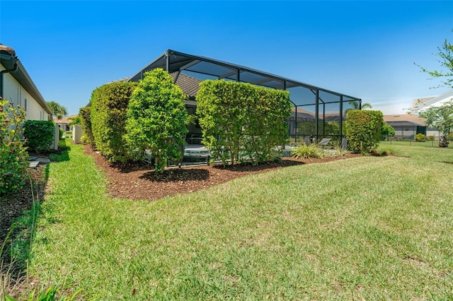 view of grassy yard with glass enclosure