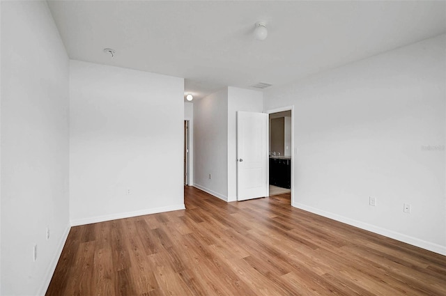 empty room with baseboards and wood finished floors