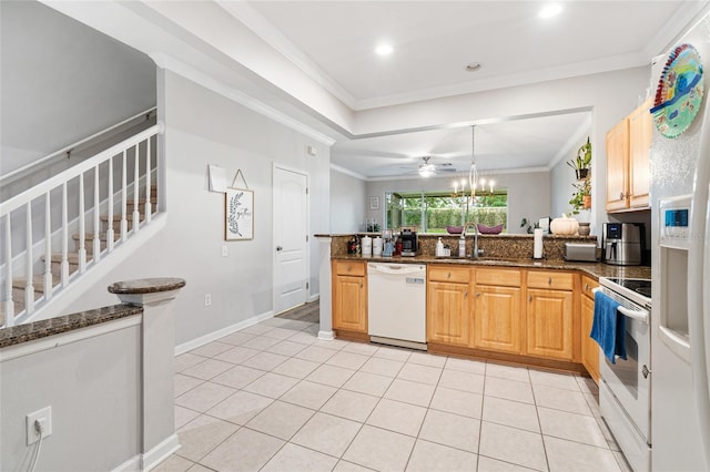 kitchen featuring a peninsula, white appliances, a sink, and crown molding