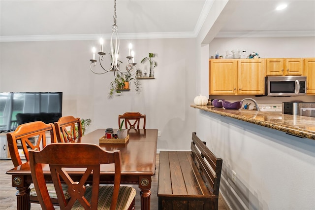 dining area with a notable chandelier, wood finished floors, and crown molding
