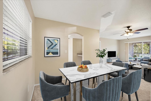 2839 Swifton Dr Unit 28, Sarasota, FL 34231 - dining area with light colored carpet, arched walkways, a ceiling fan, and baseboards