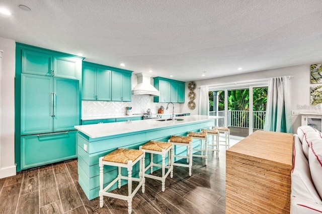 336 Avenida De Mayo, Sarasota, FL 34242 - kitchen featuring a kitchen island with sink, dark wood-style floors, custom range hood, and light countertops