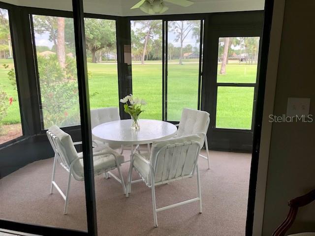 sunroom / solarium featuring outdoor dining area, ceiling fan, and plenty of natural light
