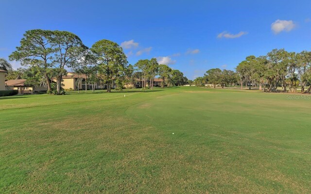 surrounding community featuring view of golf course and a yard