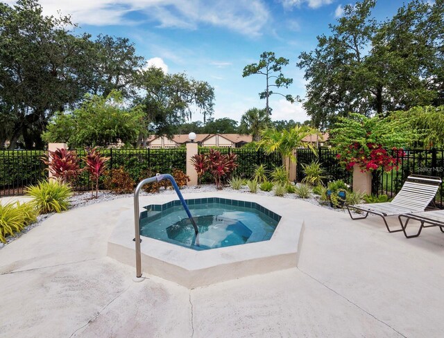 view of swimming pool featuring a hot tub, a patio, and a fenced backyard