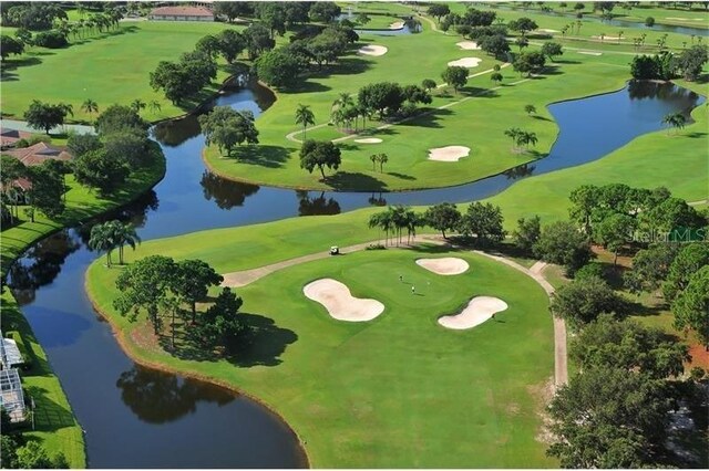 birds eye view of property with a water view and golf course view