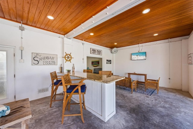 kitchen featuring a kitchen breakfast bar, a peninsula, recessed lighting, stone countertops, and wooden ceiling