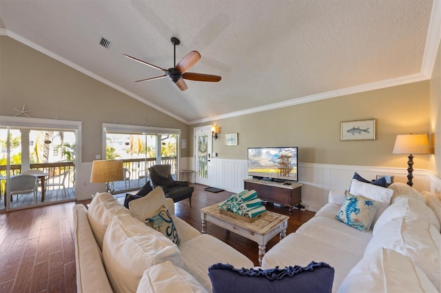 living area featuring a textured ceiling, wood finished floors, ceiling fan, and a wainscoted wall