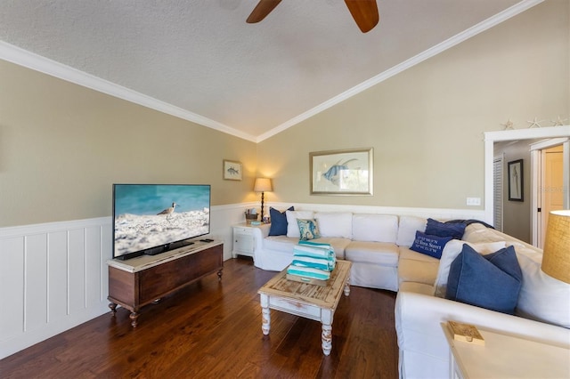 living area featuring ornamental molding, ceiling fan, wood finished floors, a wainscoted wall, and lofted ceiling