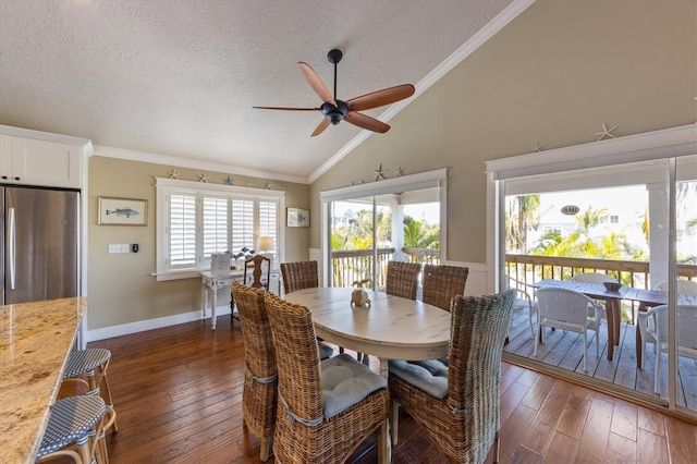 dining space with ornamental molding, a ceiling fan, a textured ceiling, dark wood-style floors, and lofted ceiling