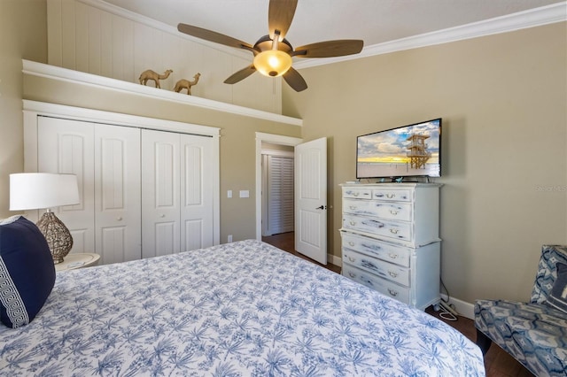 bedroom featuring a closet, baseboards, ceiling fan, crown molding, and wood finished floors
