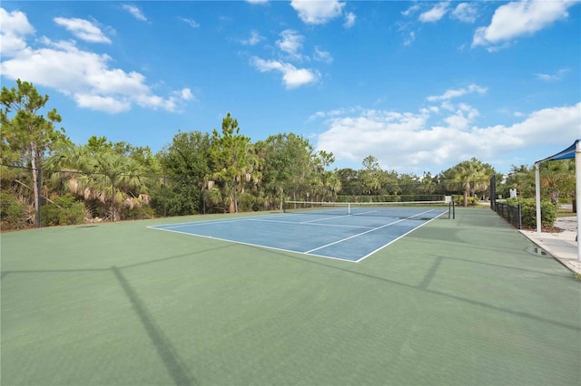 view of tennis court with community basketball court and fence