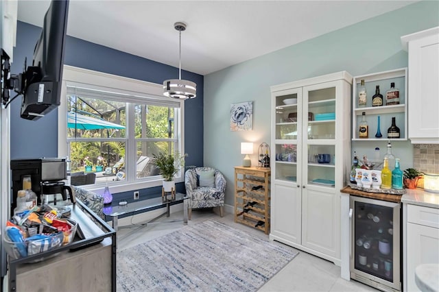interior space featuring beverage cooler, a dry bar, and a chandelier