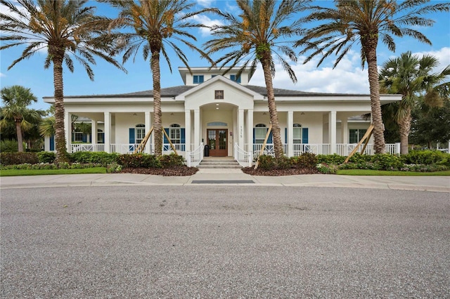 view of front of home with a porch, french doors, and stucco siding