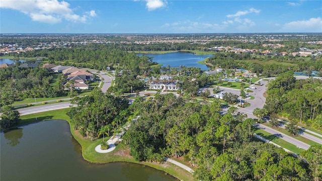 view of property location with a nearby body of water, nearby suburban area, and a tree filled landscape
