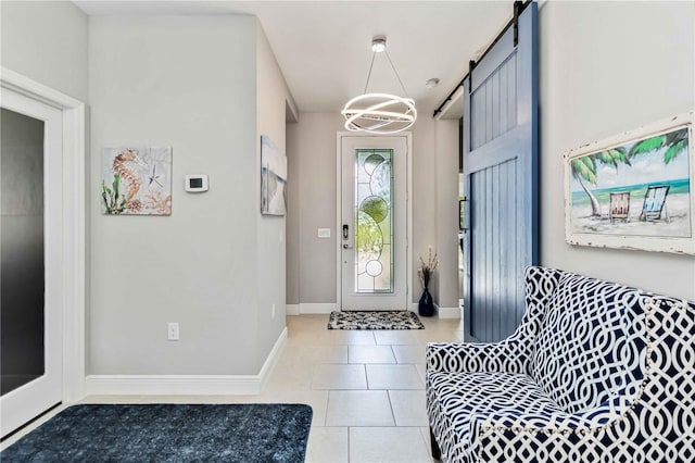 foyer featuring light tile patterned floors, baseboards, and a barn door