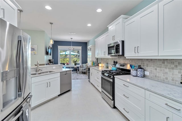 kitchen featuring stainless steel appliances, a sink, backsplash, white cabinetry, and recessed lighting