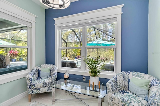 sitting room with plenty of natural light, tile patterned flooring, and baseboards